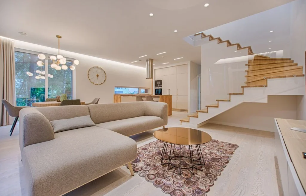 Fotografia de sala residencial com sofá e escada de madeira